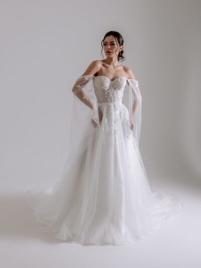 A-Linie Brautkleid aus Tüll und Glitzerspitze, herförmige Corsage nude unterlegt, versteckte Schnürung an der inneren Corsage, Glitzergürtel, Off-Shoulder Cape abnehmbar, sanfter Spitzenverlauf in den Rock, Schleppe 50cm